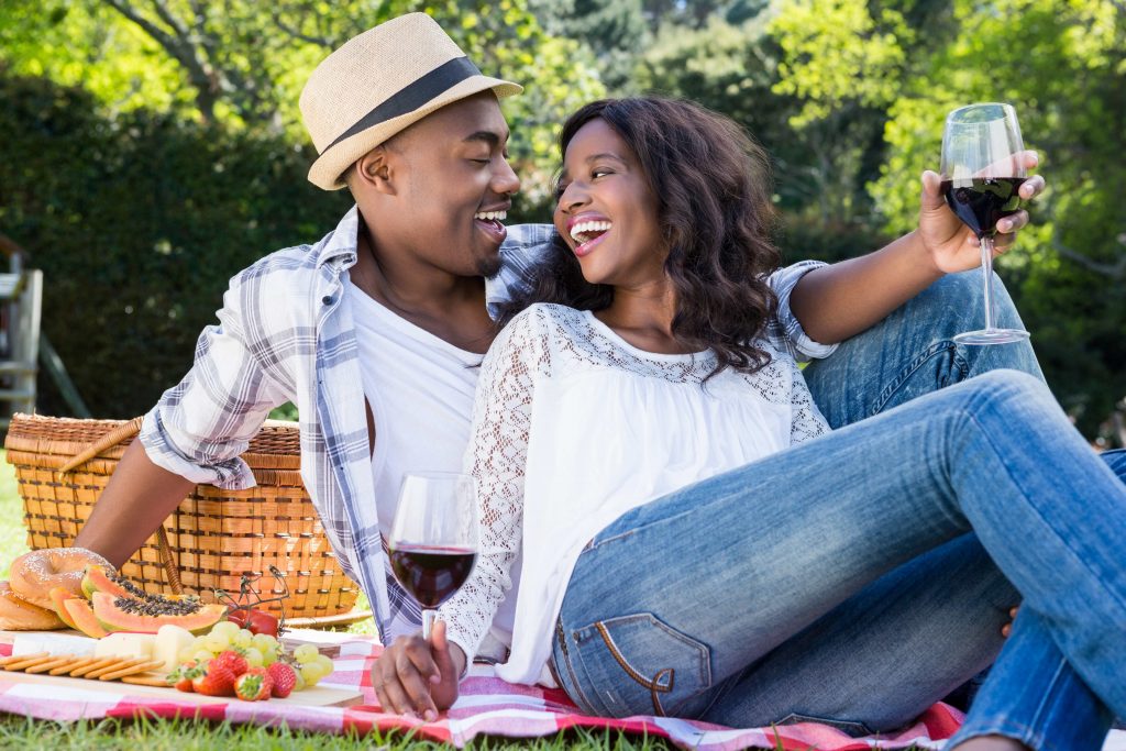 A happy african straight couple having a picnic.