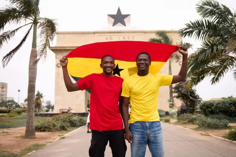 Two black men holding the ghana flag.